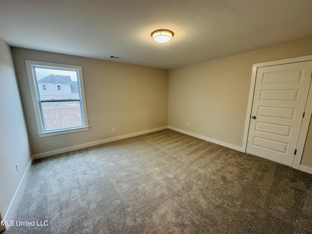 empty room with carpet flooring and baseboards