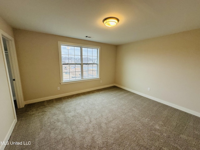carpeted spare room with baseboards
