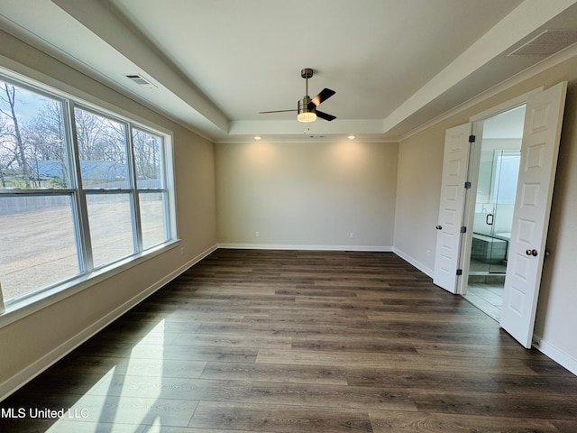 spare room with a raised ceiling, a ceiling fan, plenty of natural light, dark wood-type flooring, and recessed lighting