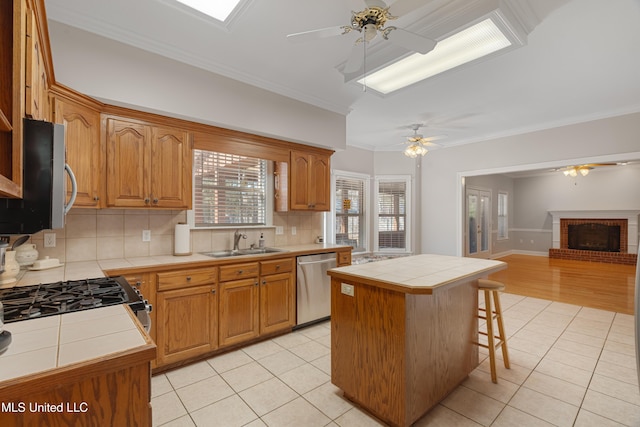 95 Sweet Bay Trl, Petal, MS 39465 - kitchen with tile countertops, stainless steel appliances, ceiling fan, a sink, and crown molding