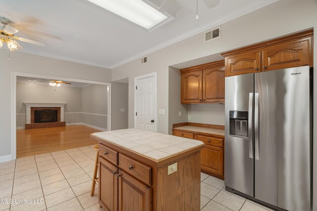 95 Sweet Bay Trl, Petal, MS 39465 - kitchen featuring stainless steel fridge with ice dispenser, a ceiling fan, tile counters, crown molding, and light tile patterned floors