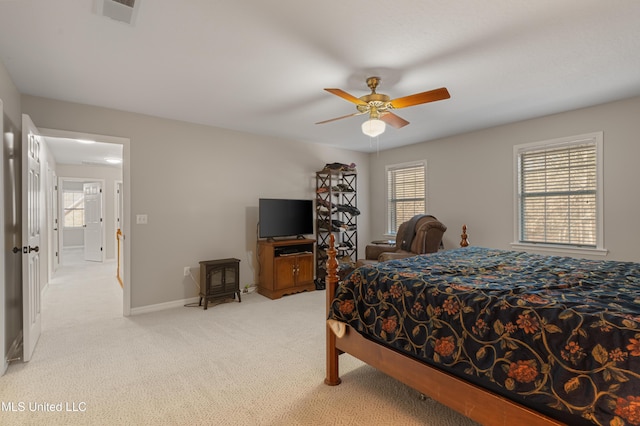 95 Sweet Bay Trl, Petal, MS 39465 - bedroom featuring a wood stove, light colored carpet, baseboards, and a ceiling fan