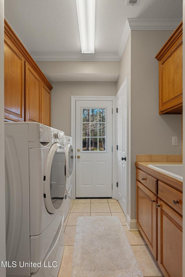 95 Sweet Bay Trl, Petal, MS 39465 - laundry room with cabinet space, washing machine and dryer, crown molding, and light tile patterned floors