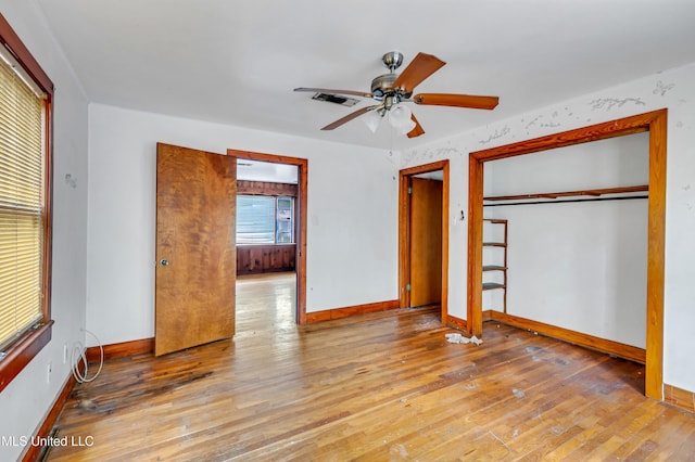 unfurnished bedroom with hardwood / wood-style floors, baseboards, and visible vents