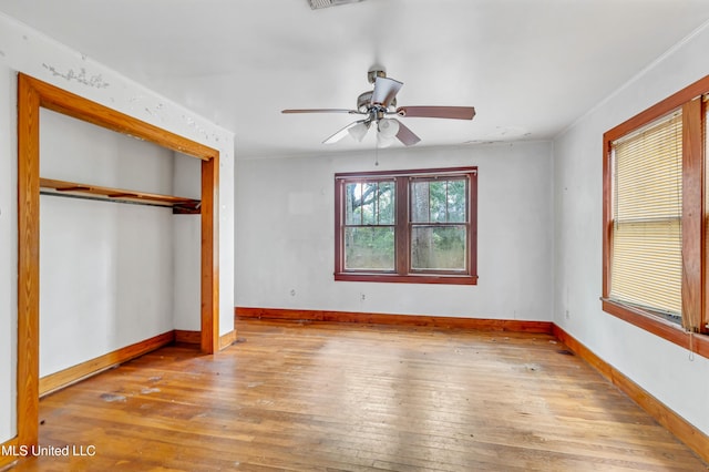 unfurnished bedroom with baseboards, visible vents, a ceiling fan, a closet, and hardwood / wood-style floors