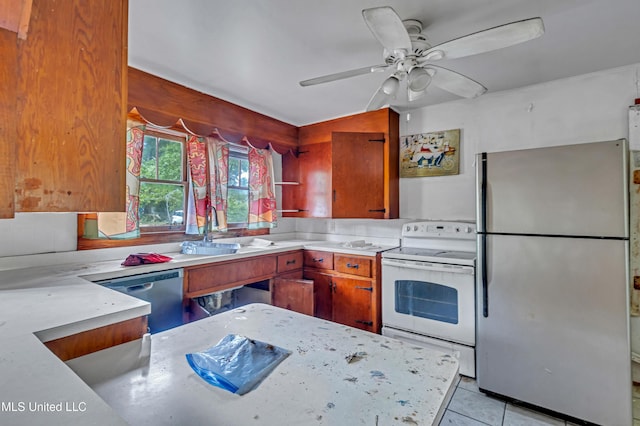 kitchen with a ceiling fan, light tile patterned floors, a sink, brown cabinetry, and appliances with stainless steel finishes