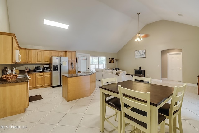 152 Sycamore Dr, Pass Christian, MS 39571 - kitchen with stainless steel refrigerator with ice dispenser, light tile patterned floors, a center island, high vaulted ceiling, and arched walkways