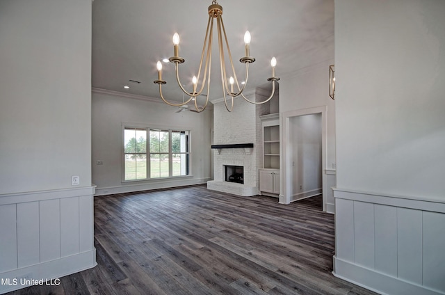 100 Grayson Way, Madison, MS 39110 - unfurnished living room with crown molding, dark wood-style floors, an inviting chandelier, a fireplace, and wainscoting