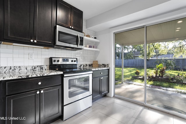 kitchen featuring tasteful backsplash, appliances with stainless steel finishes, light stone countertops, and light tile patterned flooring