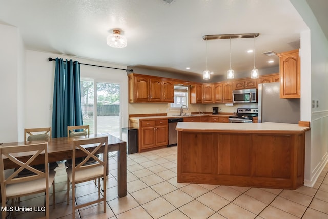 kitchen featuring stainless steel appliances, a peninsula, a sink, light tile patterned flooring, and light countertops