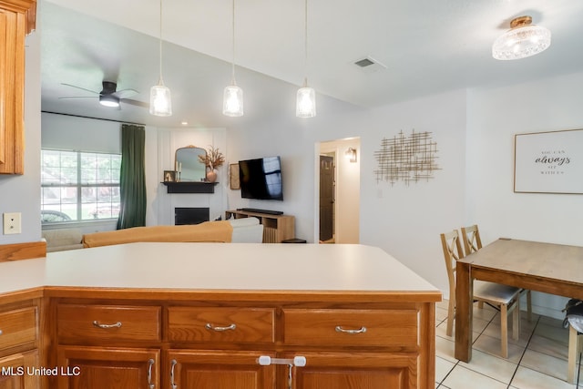 kitchen with lofted ceiling, light countertops, light tile patterned flooring, open floor plan, and ceiling fan