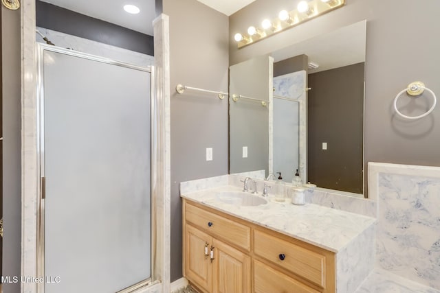 bathroom with a shower stall and vanity