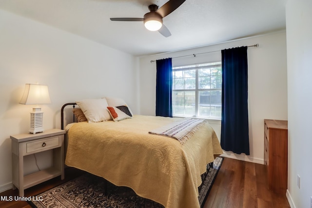 bedroom with a ceiling fan, baseboards, and dark wood-style flooring