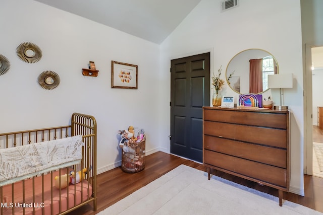 bedroom featuring visible vents, baseboards, vaulted ceiling, and wood finished floors
