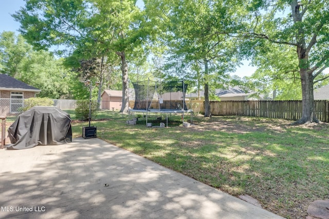 view of yard with a patio, a fenced backyard, and a trampoline