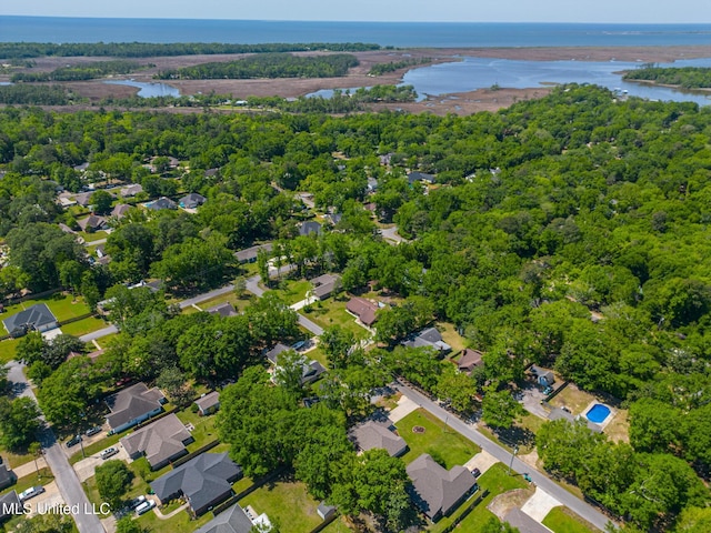 drone / aerial view with a view of trees, a water view, and a residential view