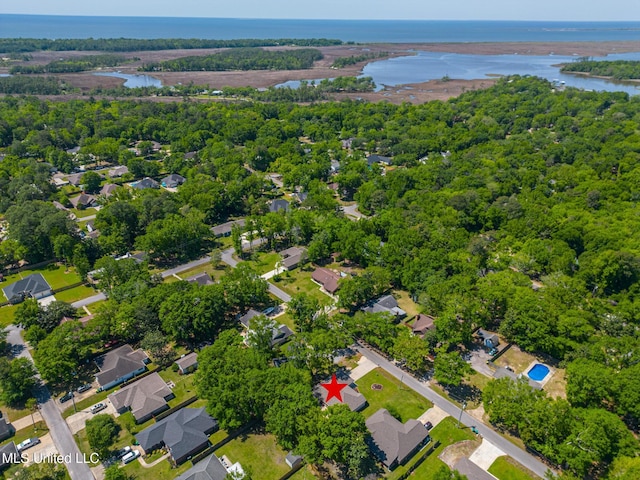 birds eye view of property featuring a forest view and a water view