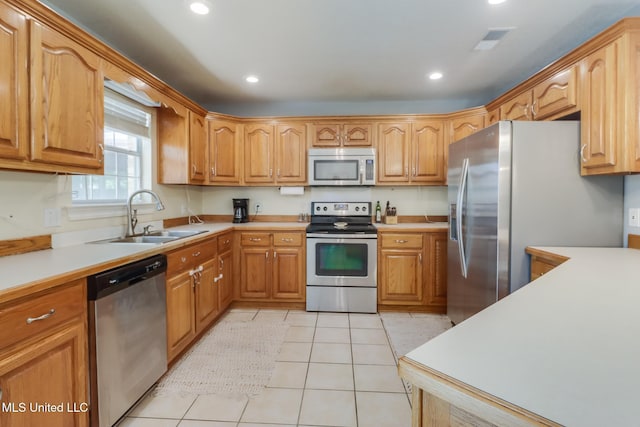 kitchen with recessed lighting, stainless steel appliances, light countertops, light tile patterned floors, and a sink