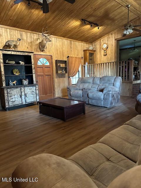 living area featuring wooden ceiling, a ceiling fan, and wooden walls