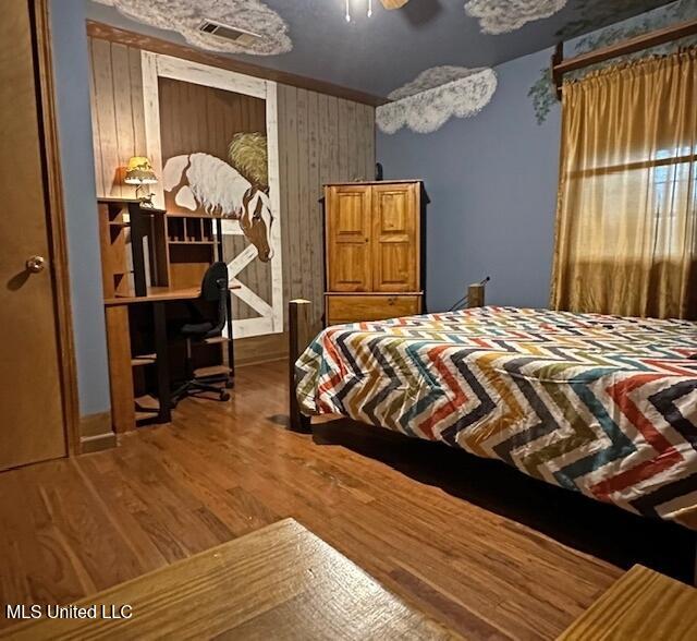 bedroom featuring visible vents, ceiling fan, and wood finished floors