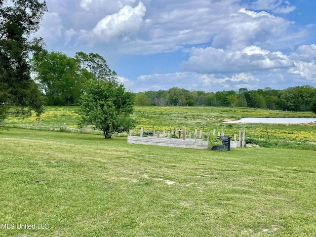 surrounding community featuring a water view, a lawn, and a rural view