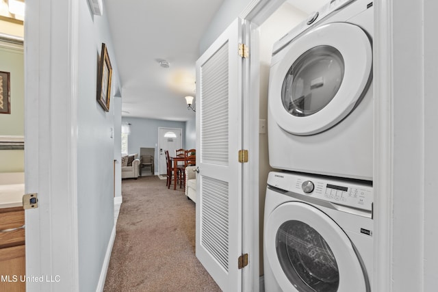laundry area featuring stacked washer / dryer, laundry area, carpet floors, and baseboards