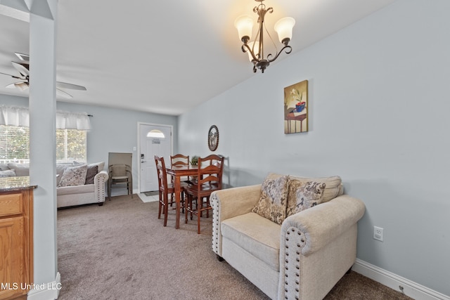 sitting room featuring carpet floors and ceiling fan with notable chandelier