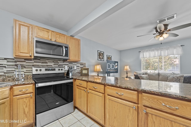 kitchen featuring dark stone counters, visible vents, stainless steel appliances, and decorative backsplash