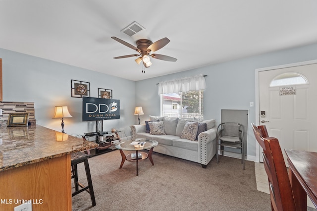 living area with visible vents, ceiling fan, and light carpet
