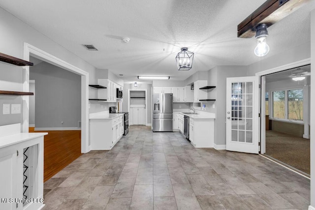 139 Booth Cir, Ocean Springs, MS 39564 - kitchen featuring open shelves, appliances with stainless steel finishes, light countertops, white cabinets, and a textured ceiling