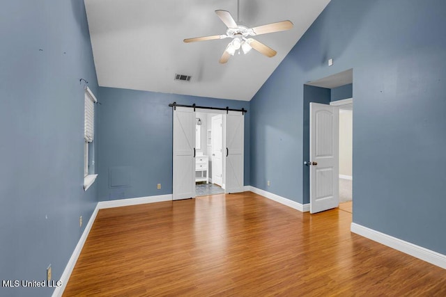 139 Booth Cir, Ocean Springs, MS 39564 - unfurnished room featuring a barn door, ceiling fan, wood finished floors, and high vaulted ceiling