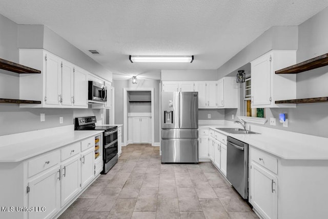 139 Booth Cir, Ocean Springs, MS 39564 - kitchen with open shelves, stainless steel appliances, white cabinetry, and a textured ceiling