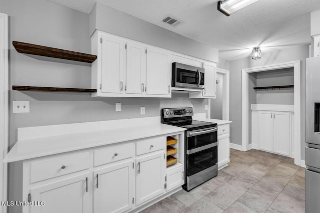 139 Booth Cir, Ocean Springs, MS 39564 - kitchen with stainless steel appliances, open shelves, white cabinets, a textured ceiling, and light countertops