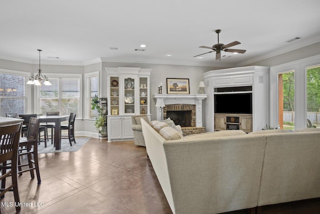 living room with plenty of natural light, baseboards, ceiling fan with notable chandelier, and a fireplace