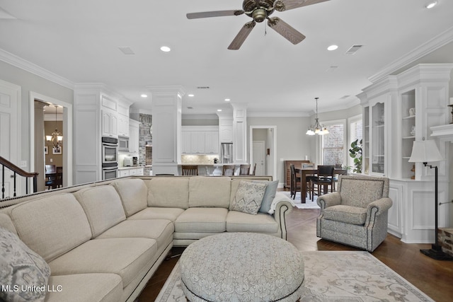 living room featuring recessed lighting, visible vents, crown molding, decorative columns, and ceiling fan with notable chandelier