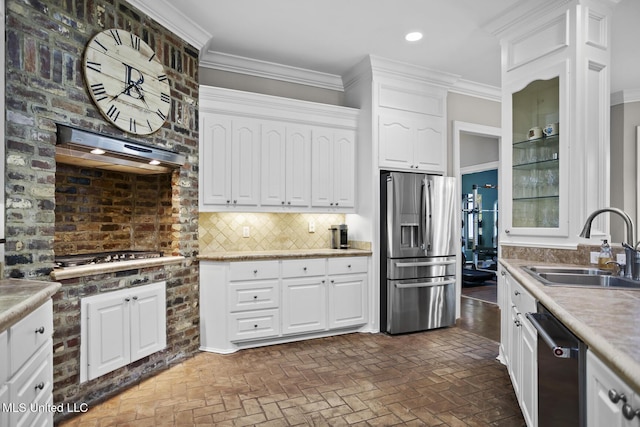 kitchen featuring brick floor, ventilation hood, appliances with stainless steel finishes, and a sink