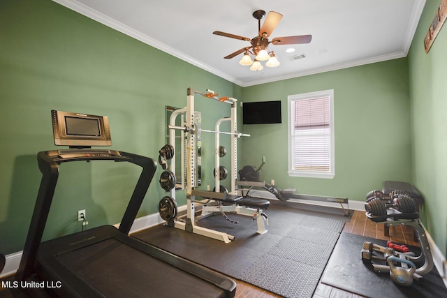 exercise room with baseboards, a ceiling fan, visible vents, and ornamental molding
