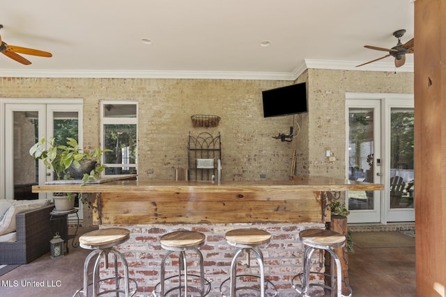 view of patio featuring an outdoor bar, a ceiling fan, and french doors