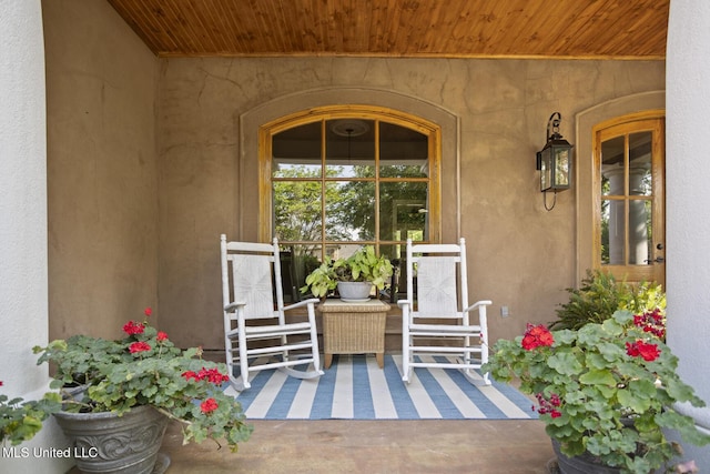 view of exterior entry with covered porch and stucco siding