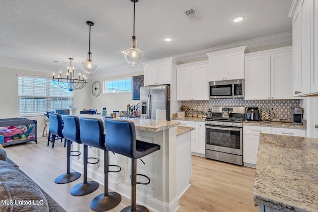 kitchen featuring crown molding, a breakfast bar, backsplash, and stainless steel appliances