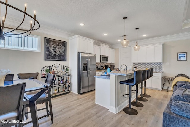 kitchen with white cabinetry, light wood-style flooring, stainless steel appliances, and a breakfast bar