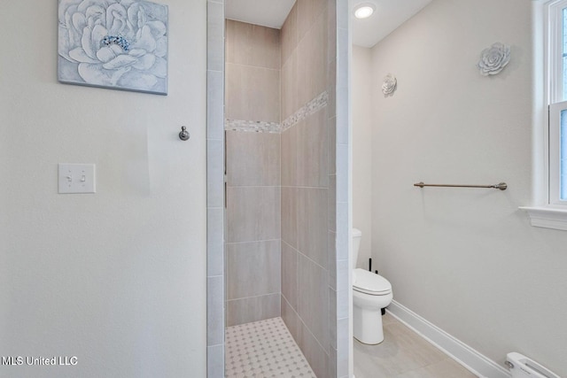 full bath with tile patterned floors, toilet, tiled shower, baseboards, and a baseboard heating unit
