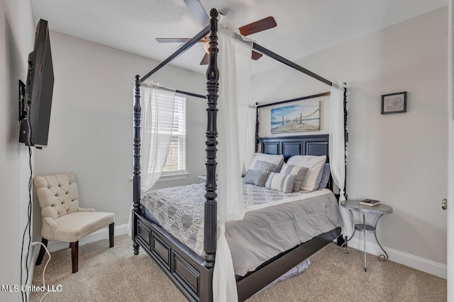 bedroom featuring baseboards, a textured ceiling, and light carpet
