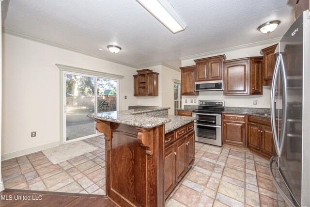 kitchen featuring light stone counters, appliances with stainless steel finishes, ornamental molding, and a kitchen island