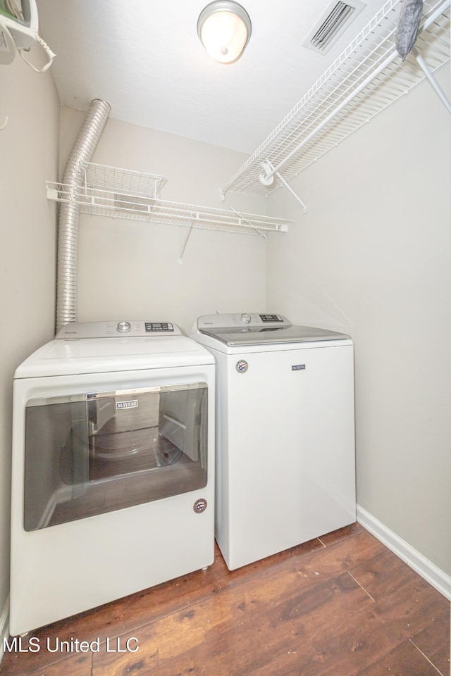 laundry room with dark wood-type flooring and independent washer and dryer