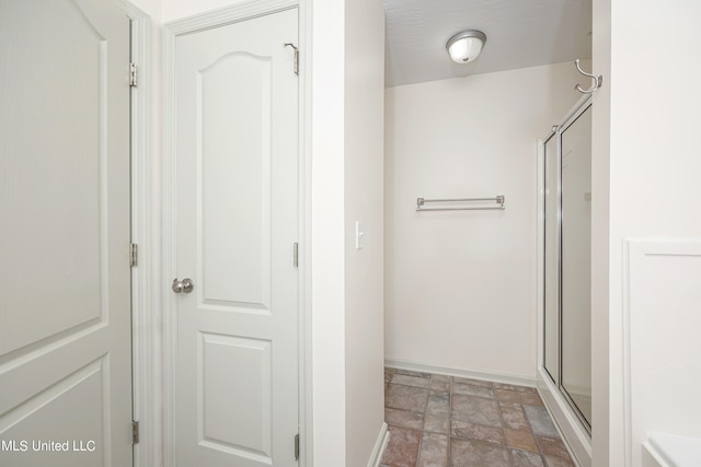 bathroom with a shower with door