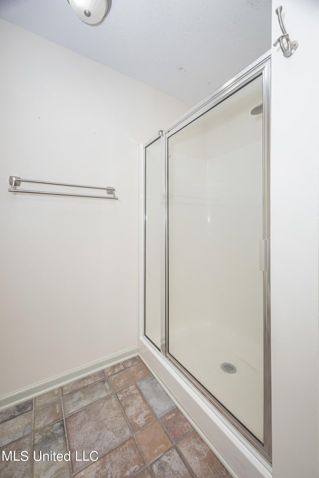 bathroom featuring a shower with door