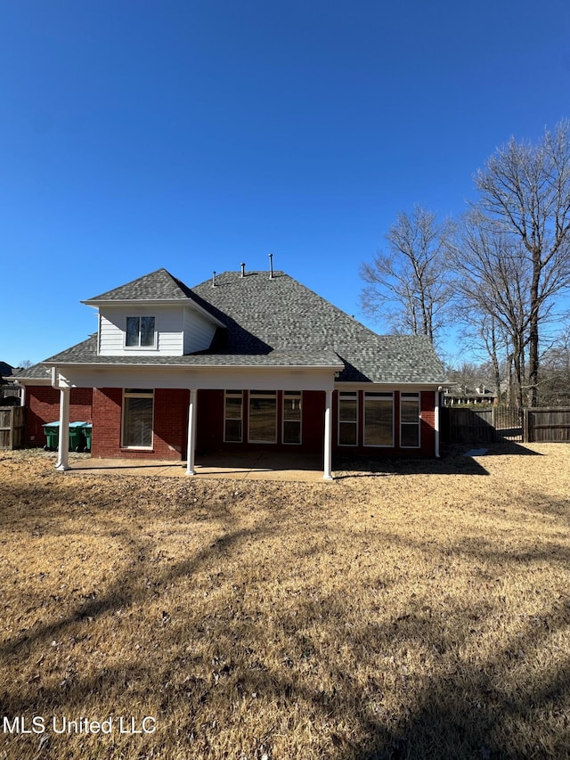 back of property with a yard and a patio area