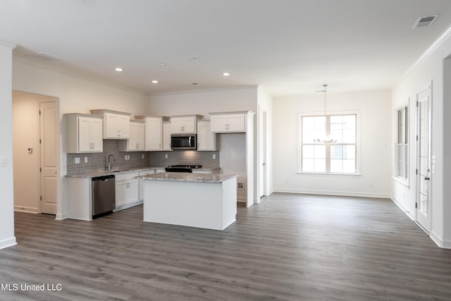 kitchen featuring appliances with stainless steel finishes, dark hardwood / wood-style floors, a center island, and white cabinetry