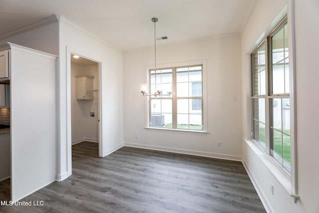 unfurnished dining area with crown molding, a healthy amount of sunlight, and dark hardwood / wood-style flooring